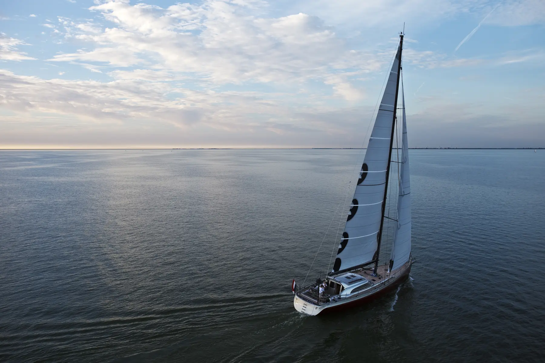 Zeiljacht onder zeil op open water, van bovenaf gefotografeerd